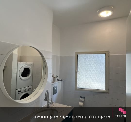 חדר אמבטיה עם מראה עגולה וכיור